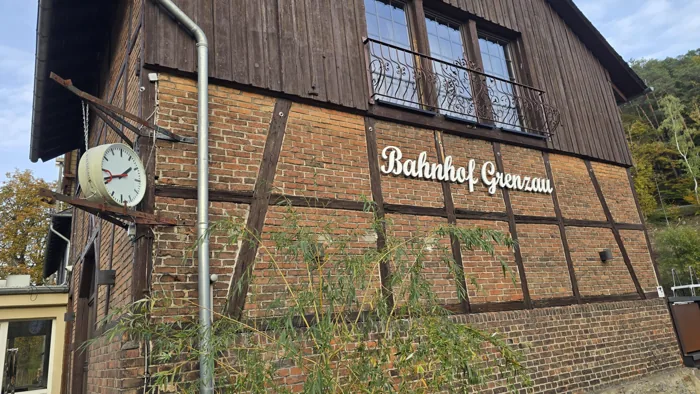 Bahnhofsuhr und Namenszug an der Fachwerkfassade am Bahnhof Grenzau